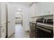 Modern laundry room features gray appliances, ample counter space and storage, connecting to the kitchen and main living areas at 7402 America Way, New Port Richey, FL 34654