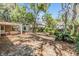 Expansive backyard featuring a brick patio with multiple outbuildings and mature trees at 7603 N 53Rd St, Tampa, FL 33617