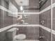 Bathroom featuring glass enclosed shower with decorative tile and overhead lighting at 7603 N 53Rd St, Tampa, FL 33617
