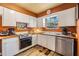 Cozy kitchen featuring white cabinets, wood countertops and stainless steel dishwasher at 7603 N 53Rd St, Tampa, FL 33617