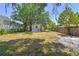 Fenced backyard with outbuilding, offering privacy and extra storage space, set against a backdrop of trees at 850 Center Ave, Brandon, FL 33511