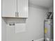 A utility room featuring cabinets, hot water tank and modern flooring at 850 Center Ave, Brandon, FL 33511
