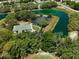 A community clubhouse is featured with a parking lot, tennis courts, and adjacent lake at 9010 Bonnet Way, Weeki Wachee, FL 34613