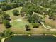 View from above overlooking the green expanse of a golf course and the still surface of a lake at 9010 Bonnet Way, Weeki Wachee, FL 34613