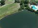 Aerial view showcasing a lake with a community pool and green common area at 9010 Bonnet Way, Weeki Wachee, FL 34613