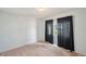A bright bedroom featuring neutral walls, carpet, and a window with dark curtains at 9010 Bonnet Way, Weeki Wachee, FL 34613