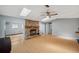 Bright living room showcasing wood floors, a stone fireplace, fan, and skylights for ample natural light at 9010 Bonnet Way, Weeki Wachee, FL 34613