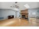 Spacious living room with hardwood floors, stone fireplace, fan, and skylights for ample natural light at 9010 Bonnet Way, Weeki Wachee, FL 34613