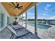 Spacious backyard patio with lounge chairs, columns, wood ceiling, and a pool offering a perfect blend of comfort and style at 935 Chipaway Dr, Apollo Beach, FL 33572