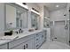 Bright bathroom offers dual sinks, modern cabinets, and a frameless glass shower with marble tile at 935 Chipaway Dr, Apollo Beach, FL 33572