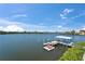 Picture of a boat dock over calm water on a sunny day, featuring two jet skis and a covered boat lift at 935 Chipaway Dr, Apollo Beach, FL 33572