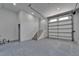 Spacious garage features epoxy flooring, a staircase, and an automatic garage door at 935 Chipaway Dr, Apollo Beach, FL 33572
