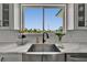 Kitchen sink with a view of palm trees and modern faucet with white cabinets and countertops at 935 Chipaway Dr, Apollo Beach, FL 33572