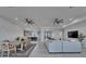 Open-concept living room with kitchen view, ceiling fans, modern furniture, and neutral color palette at 935 Chipaway Dr, Apollo Beach, FL 33572