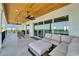 Covered outdoor living space features plush seating, ceiling fans, wood ceiling, and seamless access to water views at 935 Chipaway Dr, Apollo Beach, FL 33572