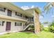 Condo building featuring stone accents, outdoor staircases, and well-maintained lawns at 9851 113Th St # 206, Seminole, FL 33772