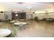 Large community center hall featuring tables, chairs, stage, and an American flag at 9950 47Th N Ave # 311, St Petersburg, FL 33708