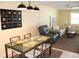 Dining area with seating for four adjacent to a living area with a ceiling fan and a large painting at 9950 47Th N Ave # 311, St Petersburg, FL 33708