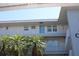 Condominium building featuring white railings, light gray exterior and palm trees on the grounds at 9950 47Th N Ave # 311, St Petersburg, FL 33708