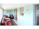 Bright sun room with red cushioned sofa, fish decorations on wall, and view of outside at 9950 47Th N Ave # 311, St Petersburg, FL 33708