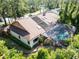 Aerial view of home with solar panels, a pool, and lush greenery at 10 Greenhaven Cir, Oldsmar, FL 34677