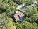 Overhead shot of a home with a screen enclosed pool, solar panel and skylights in a verdant, wooded neighborhood at 10 Greenhaven Cir, Oldsmar, FL 34677