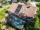 Aerial view of the home's roof, skylights, solar panels and screened pool, surrounded by mature greenery at 10 Greenhaven Cir, Oldsmar, FL 34677