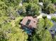 Birds-eye view of a house with pool, skylights, and solar panel, nestled among lush trees in a neighborhood at 10 Greenhaven Cir, Oldsmar, FL 34677