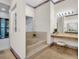 Bathroom featuring a soaking tub with a tile surround and vanity area, offering spa-like comfort and style at 10 Greenhaven Cir, Oldsmar, FL 34677