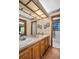 A bathroom features double sinks with wood cabinets and a view to the shower, blending functionality with classic design elements at 10 Greenhaven Cir, Oldsmar, FL 34677