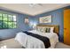 Stylish bedroom with blue walls, bright windows, ceiling fan, and bamboo-style headboard at 10 Greenhaven Cir, Oldsmar, FL 34677