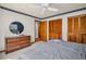 Bedroom with ceiling fan features wood closet doors and a dresser with round mirror at 10 Greenhaven Cir, Oldsmar, FL 34677