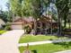 Charming brick home featuring a well-manicured lawn and mature trees providing ample shade at 10 Greenhaven Cir, Oldsmar, FL 34677
