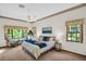 Serene main bedroom featuring large windows with lush green backyard views at 10 Greenhaven Cir, Oldsmar, FL 34677