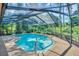 A pristine screened-in pool surrounded by lush greenery offers a private and tranquil outdoor retreat at 10 Greenhaven Cir, Oldsmar, FL 34677