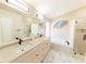Luxurious bathroom featuring double sinks, modern fixtures, soaking tub, and glass shower at 10918 Lake Andover Blvd, Tampa, FL 33624