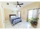 Bright bedroom with a ceiling fan, windows, and lush plant, offering comfort and charm at 10918 Lake Andover Blvd, Tampa, FL 33624