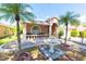 Inviting home featuring a fountain, mature palm trees, and a charming front patio at 10918 Lake Andover Blvd, Tampa, FL 33624