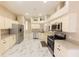 Open kitchen with stainless steel appliances, white marble floors, and neutral-toned cabinets at 10918 Lake Andover Blvd, Tampa, FL 33624