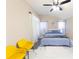 Bright main bedroom with stylish decor, modern ceiling fan, and comfortable yellow chairs at 10918 Lake Andover Blvd, Tampa, FL 33624