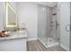 Bright bathroom with a large mirror with vanity lighting and glass-enclosed shower at 11 Franklin S Ct # C, St Petersburg, FL 33711