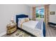 Cozy bedroom with a blue tufted headboard bed and a pleasant water view from the window at 11 Franklin S Ct # C, St Petersburg, FL 33711