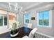 Dining room boasts a chandelier and large windows with great views of outdoor greenery and waterfront at 11 Franklin S Ct # C, St Petersburg, FL 33711
