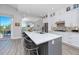Modern kitchen with a gray island, seating, stainless steel appliances, and access to the dining room at 11 Franklin S Ct # C, St Petersburg, FL 33711