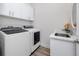 Clean laundry room with modern washer and dryer units, storage cabinets, and sink at 11 Franklin S Ct # C, St Petersburg, FL 33711