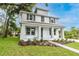 Inviting two-story home with a spacious front porch, featuring well-kept landscaping and fresh green grass at 114 W Plymouth St, Tampa, FL 33603