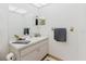 Bathroom features a mirrored medicine cabinet, toiletries, and modern gray hand towels at 11802 Foxrun Ln, Temple Terrace, FL 33617