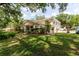 Well-maintained home exterior featuring a green lawn and mature trees at 11802 Foxrun Ln, Temple Terrace, FL 33617