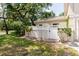 Charming exterior featuring a private entrance, a white fence, and lush greenery at 11802 Foxrun Ln, Temple Terrace, FL 33617