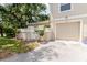 Exterior featuring a private entrance, an attached garage, and mature trees providing shade at 11802 Foxrun Ln, Temple Terrace, FL 33617